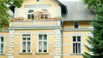 Fototapeta na wymiar Yellow Old Brick Stone Building With Balcony