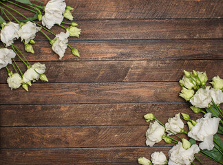 White eustoma flowers on wooden background with copy-space.