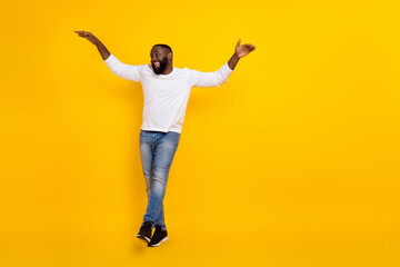 Full size portrait of excited crazy young man partying clubbing spend pastime isolated on yellow color background