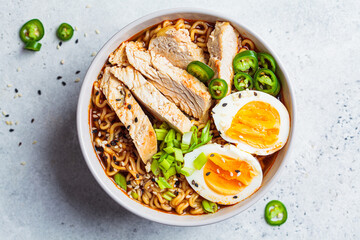 Asian noodle soup ramen with chicken and egg in gray bowl. Japanese food concept.