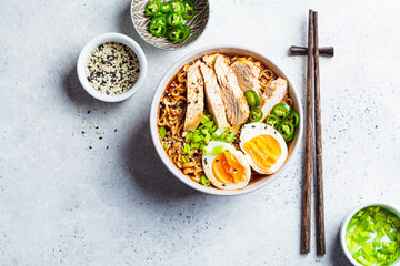 Asian noodle soup ramen with chicken and egg in gray bowl. Japanese food concept.