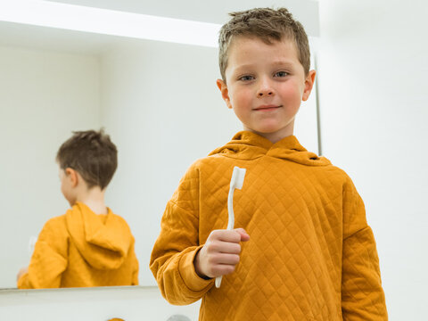 Portrait of boy with toothbrush in bathroom
