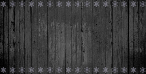 Old vertical wooden shabby dark gray background and horisontal rows of silver snowflakes, seasonal, card, greetings, holiday