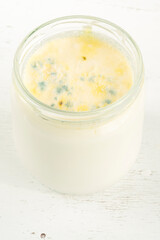 closeup rotten yogurt or yoghurt in jar on wooden background