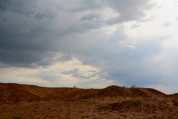 Big sand dune looking as mountain and blue sky with clouds on the background
