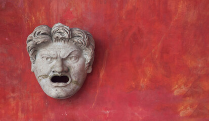 Copy of an antique theatre mask isolated on a red background