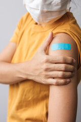 woman showing bandage after receiving covid 19 vaccine. Vaccination, herd immunity, side effect,...