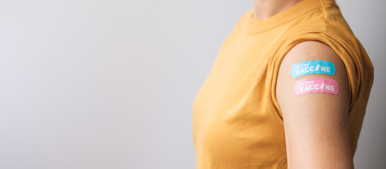 woman showing plaster after receiving covid 19 vaccine. Vaccination, herd immunity, side effect, booster dose, vaccine passport and Coronavirus pandemic