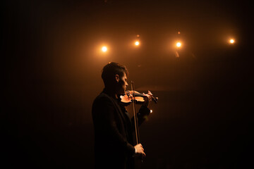 WIDE young aspiring musician playing violin on a stage of a large venue. Shot with 2x anamorphic lens © supamotion