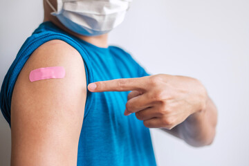 man showing bandage after receiving covid 19 vaccine. Vaccination, herd immunity, side effect,...