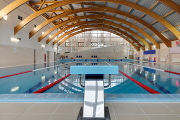 Indoor swimming pool, starting block, diving block and marked lanes, flat calm water