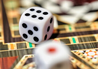 Close up with selective focus of dice on a colorful game board for a game of chance