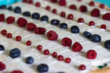 The process of cooking meringue roll, berries on cream