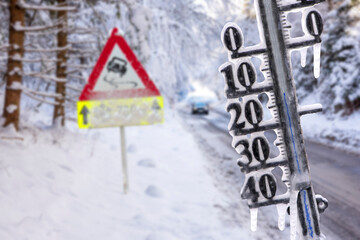 road sign warns of ice and snow at winter