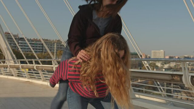Happy young women embracing and laughing while having piggyback ride