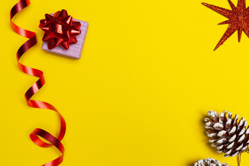 Gift box with a red bow on yellow background with free space for greetings. New year gift, space for present list.