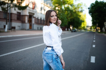 Beautiful girl in jeans and a white blouse.