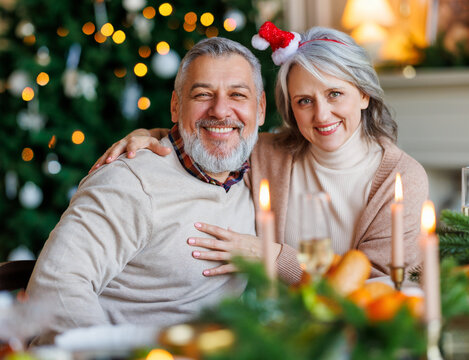 Portrait of happy senior family couple, grandparents, during Christmas celebration at home