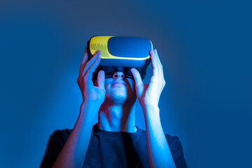 Portrait of young man in a VR helmet in neon colors