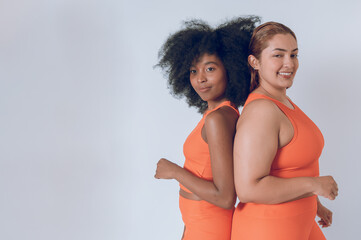 multiethnic beautiful young latin girls, with orange sportswear on a white background.