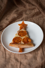 A slice of pepperoni pizza that resembles a Christmas tree. Christmas pizza. New Year