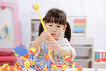 young girl playing creative 3d shape toy for homeschooling