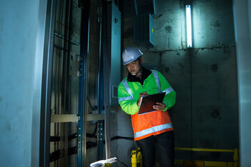 People in elevator shaft. service engineer checking inspector part of  elevator. worker check in...