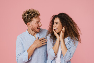 Young white man and woman expressing surprise at camera