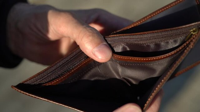 A man shows an empty wallet with no money. Business bankruptcy concept