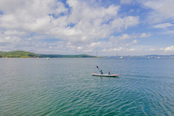 Active happy family having fun together enjoying adventurous experience kayaking on the sea on a sunny day during summer vacation