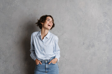Young brunette woman wearing shirt laughing and looking aside