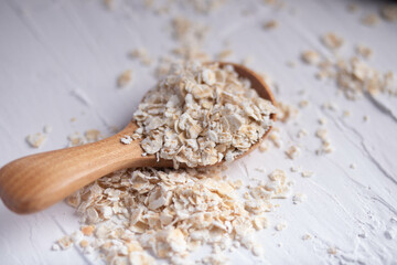 oatmeal in wooden spoon and fresh milk on white background healthy food