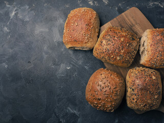 Organic whole grain rolls on a dark background, healthy food concept