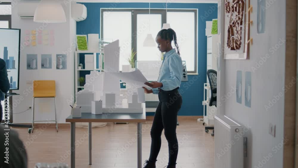 Poster architect holding blueprints plan and analyzing building model to create project strategy. architect