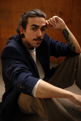 Fototapeta premium stylish young guy posing on the floor serious and thoughtful
