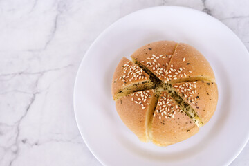 Garlic cream cheese bread or cheese bun, mozzarella cheese bun with sesame and parsley for serve on a white plate