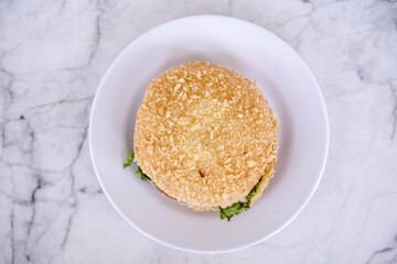 Simple beef burger  with ham and lettuce are served on a white plate. Bakery, Fast food concept. Street food concept.