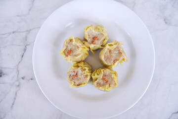 Japanese chicken dumplings Gyoza with carrot and vegetables, on a white plate