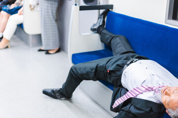 電車内で寝転ぶ中年男性
