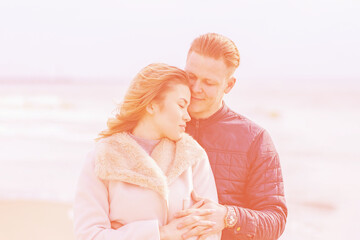 Young loving couple spending time together at spring beach.Blurred coral calm color background,close up.