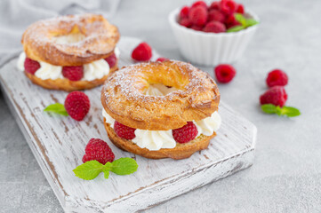 Choux pastries. Choux rings with cream of cream cheese or cottage cheese and fresh raspberries,...
