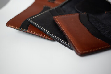 Leather wallet brown and black on a white background with leatherworking tools, leather goods