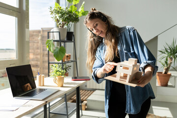 Architect pointing at model on video conference at home office