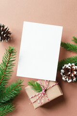 Christmas or New Year greeting card mockup with gift box and fir tree branches with cones