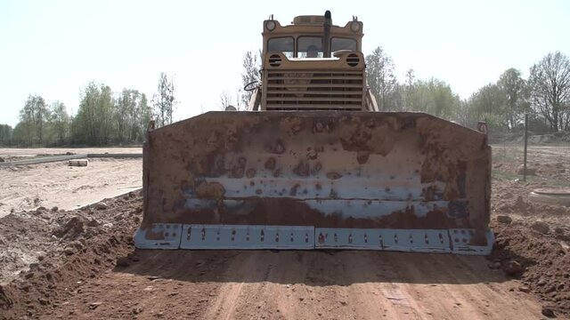 A bulldozer, dozer at a construction site is going in reverse. close-up