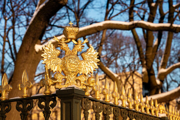 Fototapeta na wymiar Armorial double-headed eagle made of gold as a decoration on the fence. Saint Petersburg, Russia - 5 Dec 2021