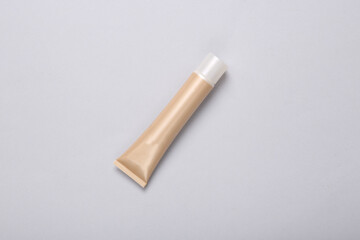 Tube of foundation on gray background. Top view