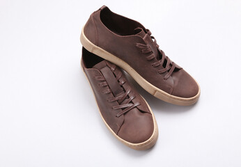 Mens brown leather sneakers on a gray background
