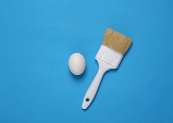 Brush and egg on a blue background