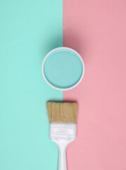 Paint Can with paintbrush on pink blue background. Top view
